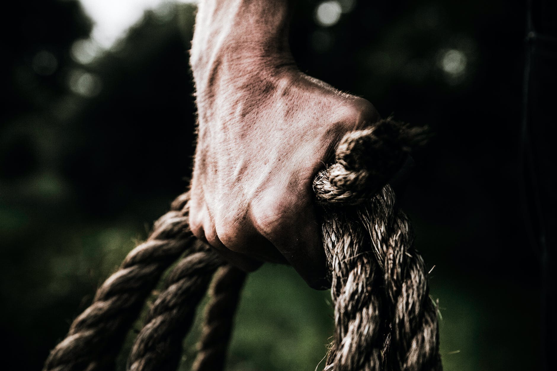 hand reaching down with a rope